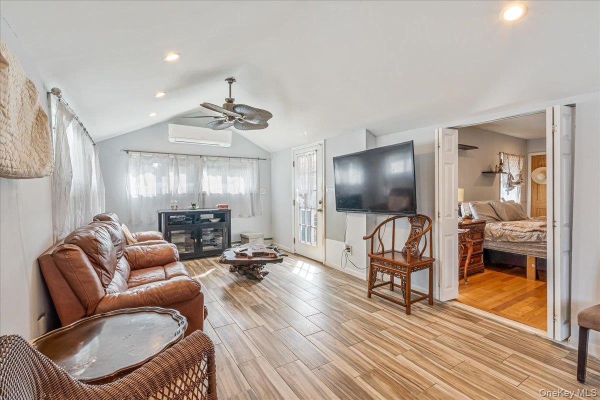 Living room with wood tiled floors, ceiling fan, and recessed lighting
