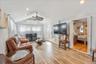 Living room with wood tiled floors, ceiling fan, and recessed lighting