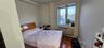 Bedroom featuring dark wood-style flooring, an AC wall unit, and a baseboard radiator