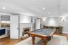 Playroom featuring wood finished floors, a tray ceiling, a fireplace, ornamental molding, and recessed lighting