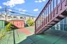 Fenced backyard with stairs, a storage shed, and a patio area