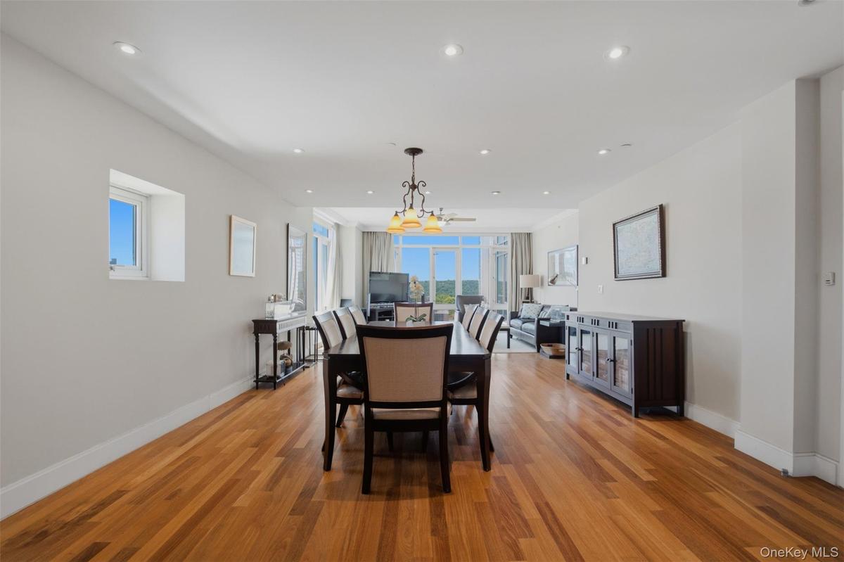 Open-concept living area featuring wood-finish flooring, recessed lighting, and expansive windows