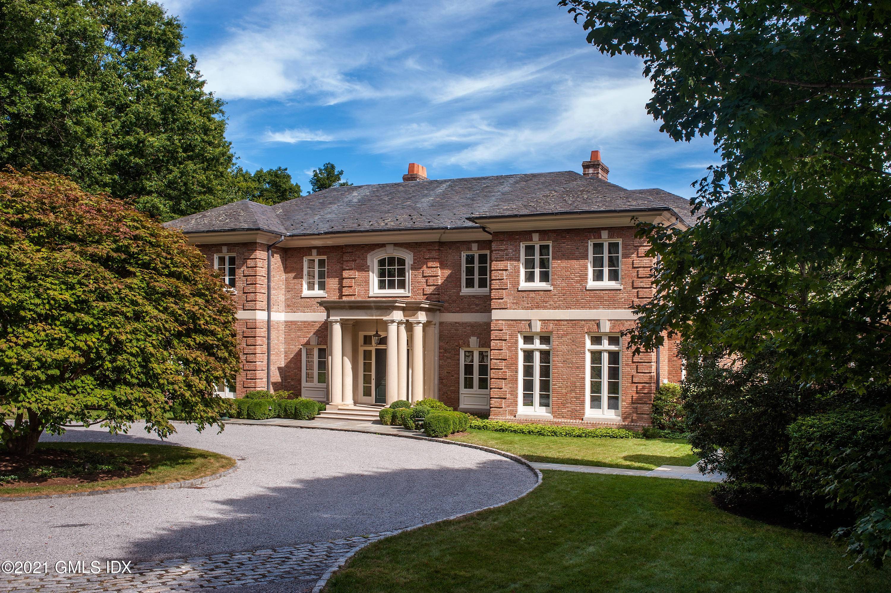 Custom brick and limestone Georgian is beautifully sited on 4 magnificent private and open acres and is located on a private lane in Round Hill.