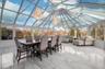 Sunroom with marble tiled floors, high vaulted ceiling, and a chandelier