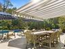 View of Pool Side Patio with Table and Awning