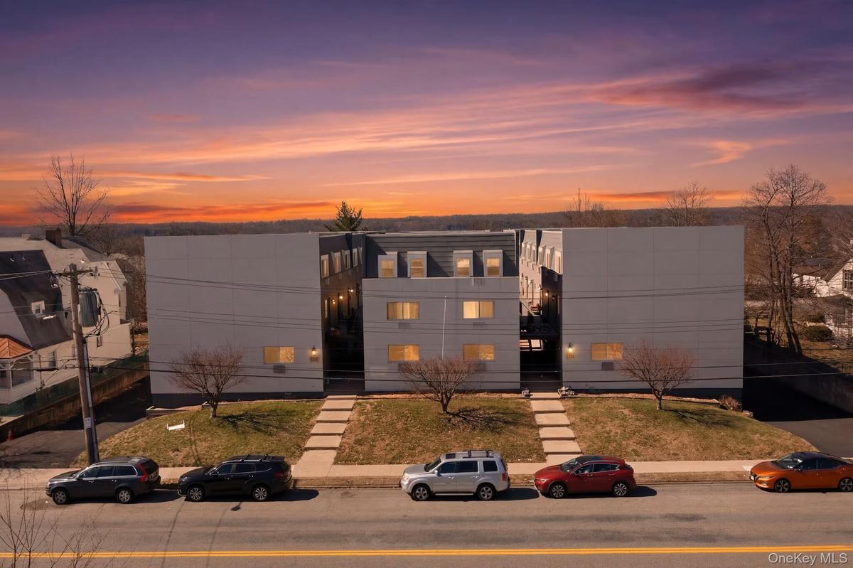 Contemporary multi-story building featuring light-toned siding and multiple windows