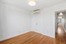 Unfurnished bedroom with light wood-style flooring, a closet, and an AC wall unit