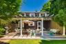 Expansive wood-finish deck with pergola structure, white columns, and a lattice privacy screen