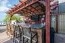 View of patio featuring area for grilling, a ceiling fan, and a pergola