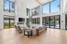 Living area with light wood finished floors and a high ceiling