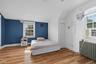 Bedroom featuring radiator, wood finished floors, vaulted ceiling