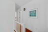 Corridor with wood finished floors and an upstairs landing