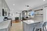Kitchen featuring backsplash, gray cabinets, recessed lighting, light stone countertops, and a peninsula