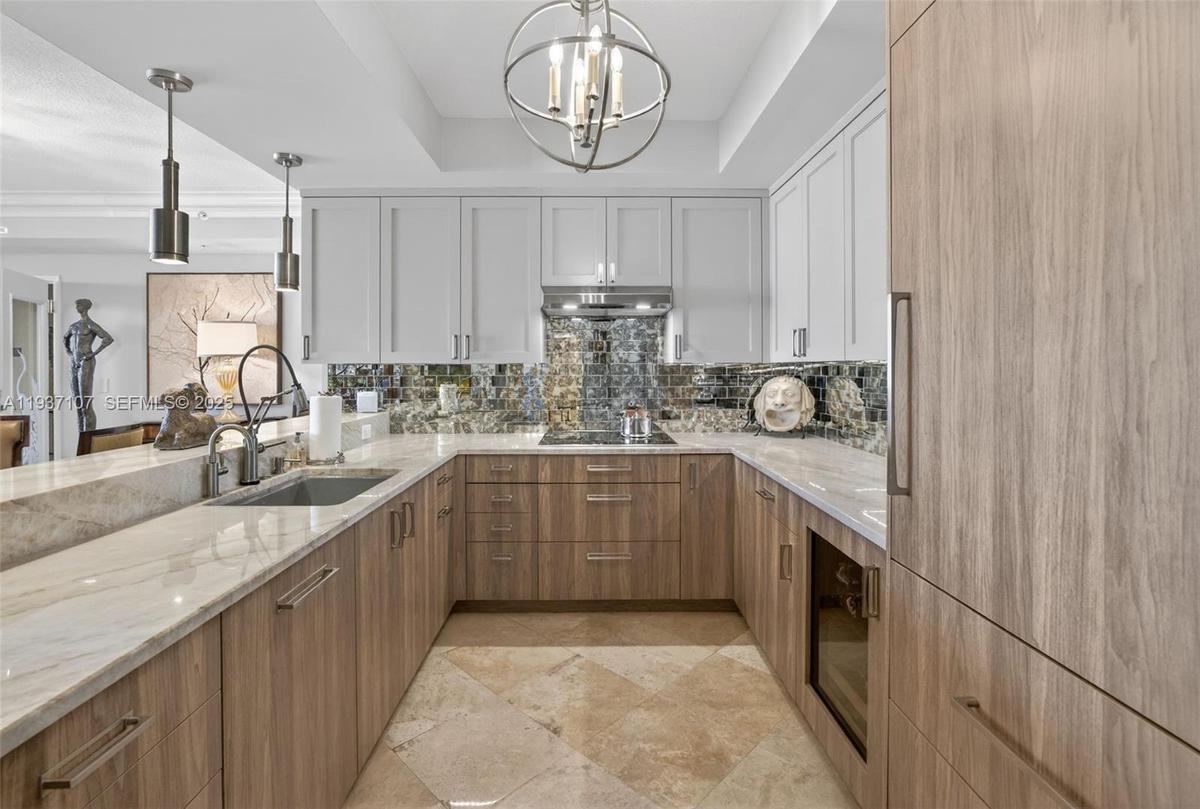 Spectacular kitchen w/ custom bleached walnut veneer cabinetry by renowned Chicago based millworker. Grain matches from top to bottom. Taj mahal quart
