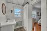 Bathroom with a closet, vanity, a wainscoted wall, a water view, and ensuite bath