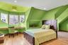 Bedroom featuring light wood finished floors, vaulted ceiling, built in desk and walk in closet