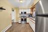 Kitchen featuring stainless steel appliances, off white cabinetry, a single basin sink, light-toned countertops, and patterned backsplash