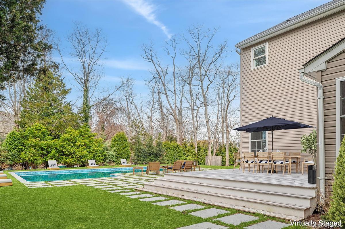 View of yard featuring an outdoor pool and a deck