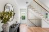 Entryway with ornamental molding, light wood finished floors, and stairs