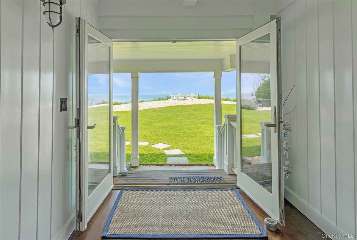 Doorway to outside with dark wood finished floors, plenty of natural light, and a water view