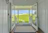 Doorway to outside with dark wood finished floors, plenty of natural light, and a water view