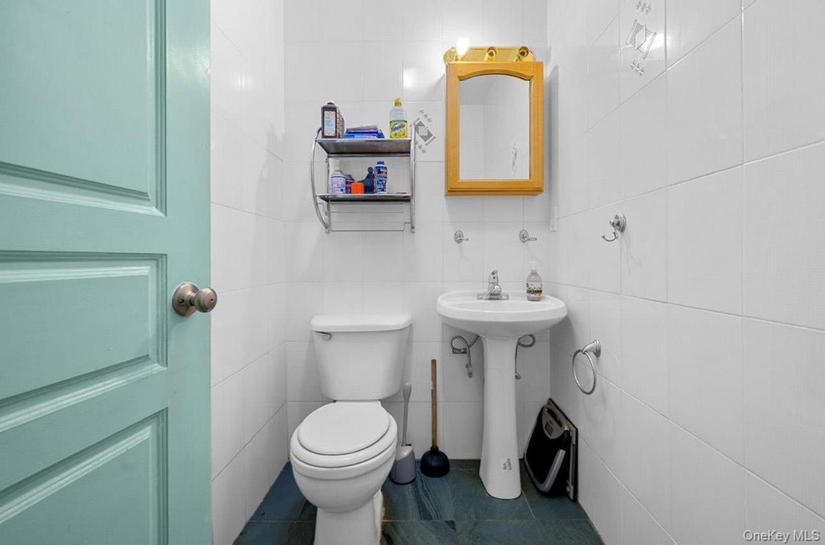 Half bathroom featuring tile walls and dark tile patterned floors