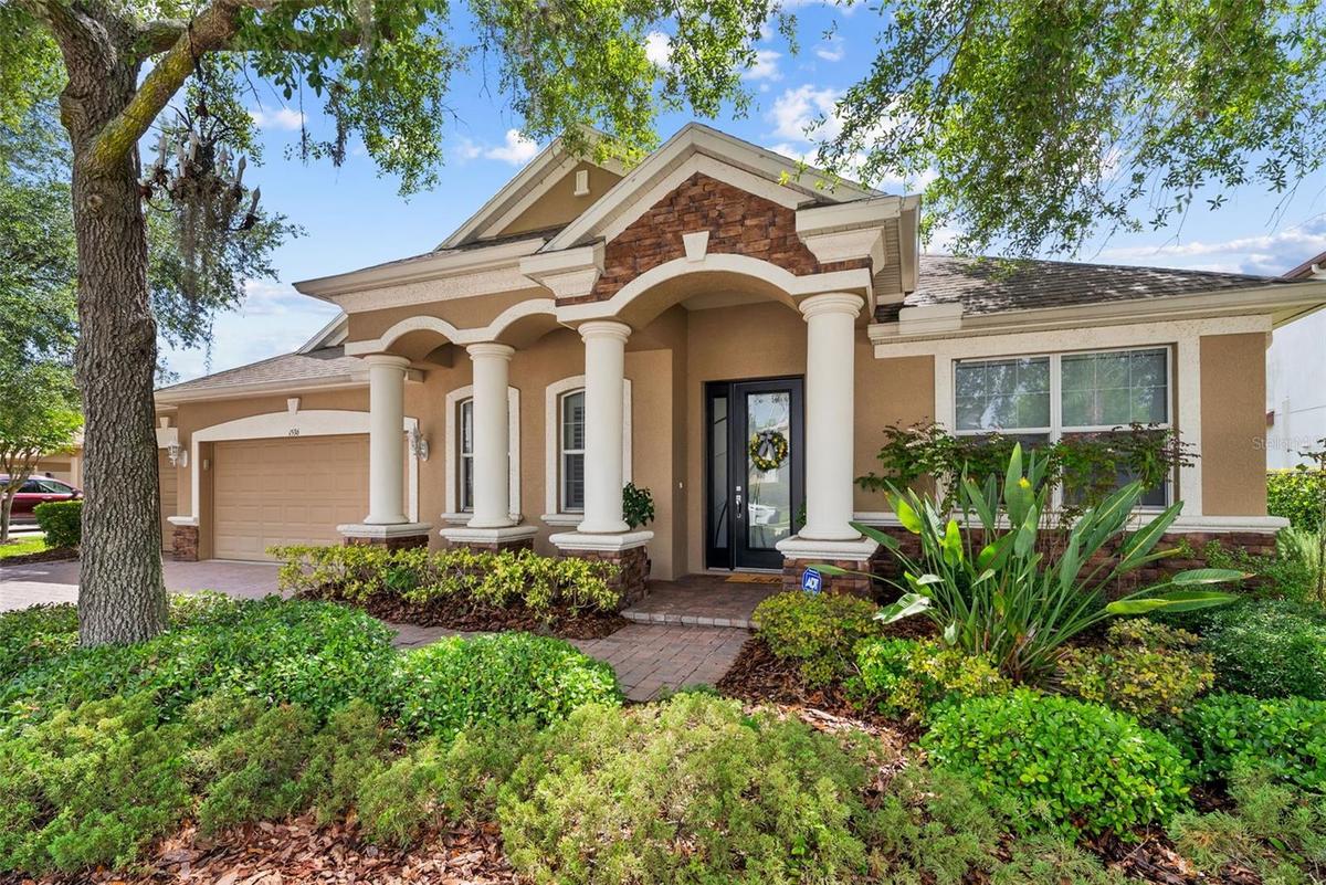 Beautiful curb appeal with mature landscaping and welcoming covered entry.