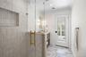 Full bathroom with light marble finish flooring, vanity, a shower stall, ornamental molding, and recessed lighting