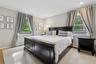 Bedroom with a baseboard heating unit, light wood finished floors, and recessed lighting