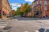View of asphalt street featuring sidewalks, curbs, and street lighting