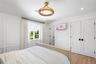 Bedroom with a decorative wall, wood finished floors, lofted ceiling, recessed lighting, and a closet