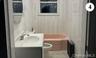 Full bathroom featuring radiator, vanity, toilet, and shower / tub combination