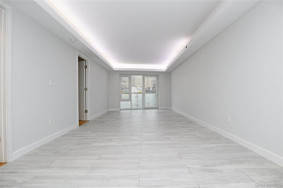 Unfurnished room with a tray ceiling and baseboards