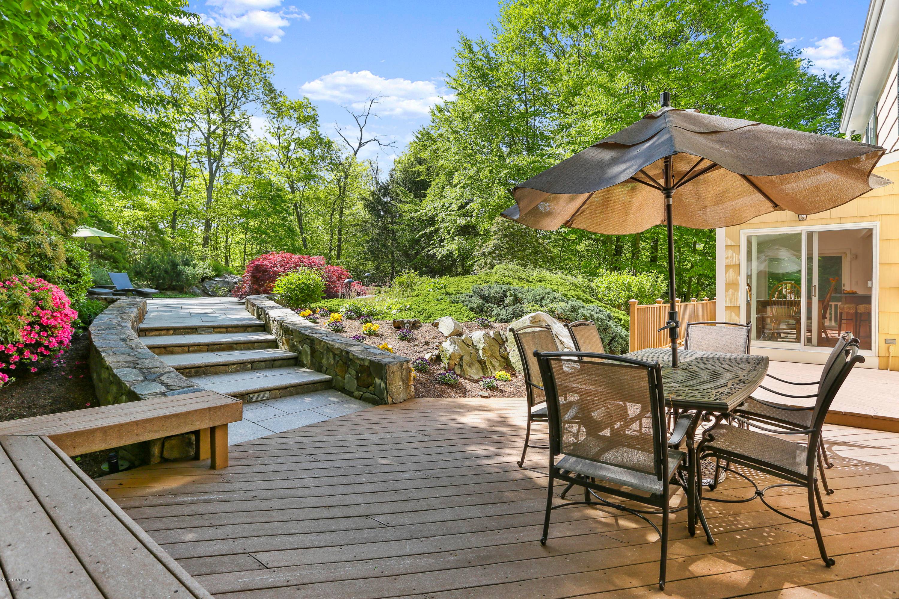 Illuminated gardens, mature trees, a waterfall and pool bring serenity to a lovely 5 BR 3.