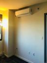 Empty room featuring a wall unit AC and baseboards