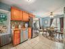 Kitchen featuring radiator heating unit, stainless steel appliances, backsplash, and brown cabinetry