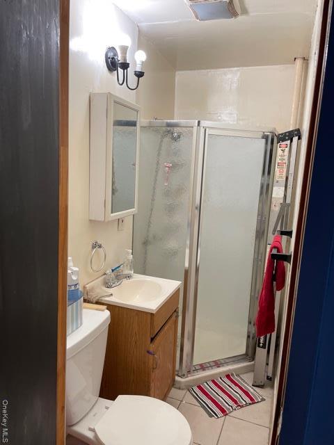 Full bathroom with light tile patterned floors, a stall shower, and vanity