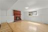 Lower level family room with traditional wood burning fireplace.