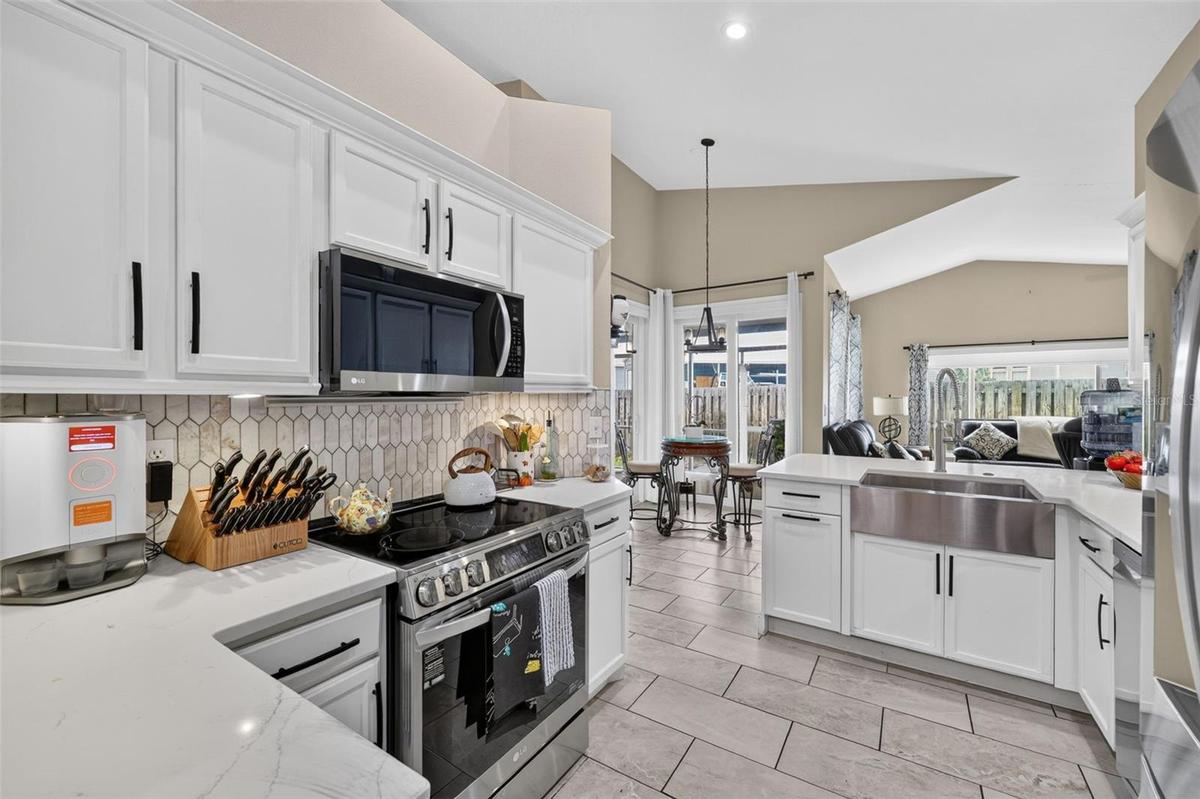 The kitchen is light and bright with stainless appliances, farmhouse sink and soft close cabinetry. This room leads to the dining aream living room an