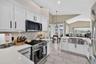 The kitchen is light and bright with stainless appliances, farmhouse sink and soft close cabinetry. This room leads to the dining aream living room an