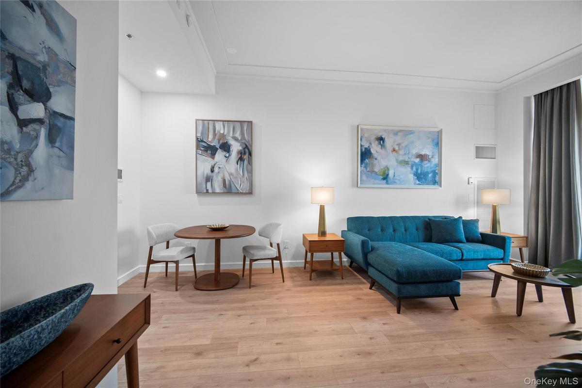 Living room featuring light wood finished floors, crown molding, baseboards, and recessed lighting