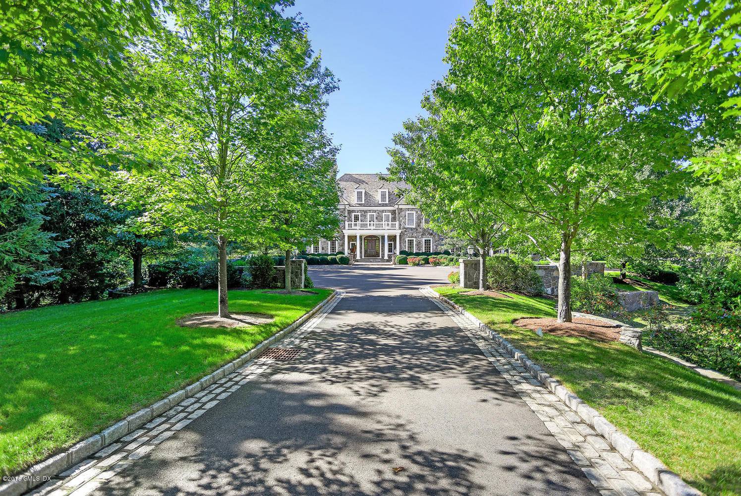 Stunning stone Georgian estate set on over 3 acres, abutting Greenwich Land Trust for unmatched privacy.