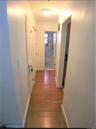 Corridor with light wood-type flooring and baseboards