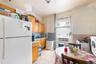 Kitchen with white appliances, light countertops, light tile patterned flooring, washer / clothes dryer, and decorative backsplash