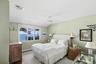 Bedroom with a water view and ceiling fan