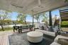 Deck with outdoor lounge area, a water view, ceiling fan, a grill, and exterior kitchen