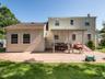 Rear view of property featuring a patio, a yard, and a chimney