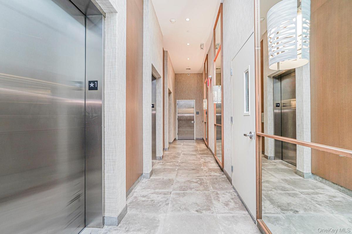 Corridor featuring elevator and recessed lighting