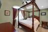Vaulted ceiling with ceiling fan, arched window with decorative curtains, and recessed lighting
