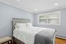 Bedroom with ornamental molding, wood finished floors, baseboard heating, and recessed lighting